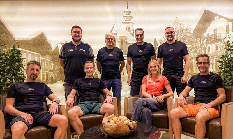Fünf Mitglieder der Trail-Community stehen lachend unter einem Schirm beim Eventgelände